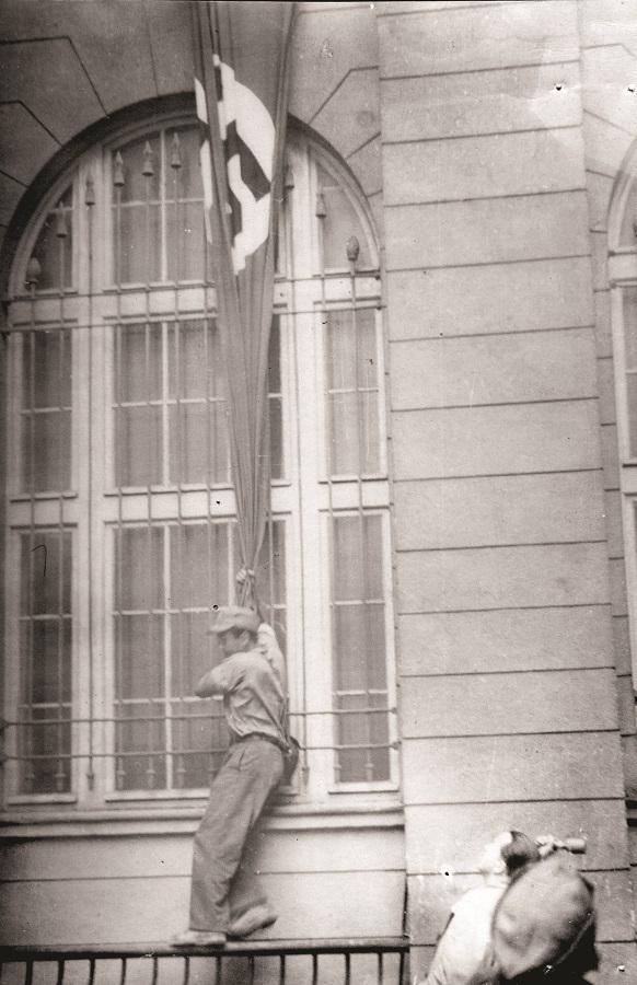 Fotoreporter Stanisław Bala ps. „Giza”, zrywa nazistowską flagę z gmachu Pocztowej Kasy Oszczędności.jpg